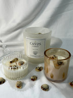 Cavos candles with seashells on a white fabric background